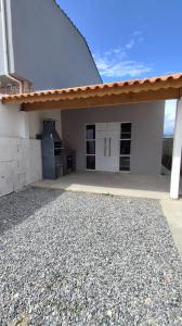 a white house with a garage and a driveway at Descanso - Casa de Praia in Mongaguá