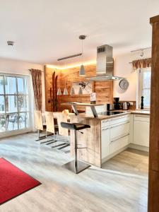 a kitchen with white cabinets and a red rug at Schofer Eck - fewo-badhindelang in Bad Hindelang