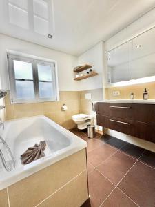 a bathroom with a large tub and a toilet at Schofer Eck - fewo-badhindelang in Bad Hindelang +21 photos