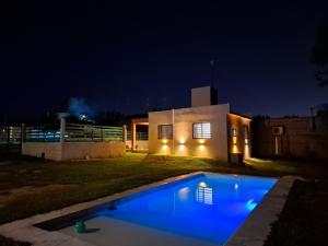 a house with a blue swimming pool at night at Complejo San roque in San Roque