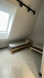 a attic room with two beds and a window at Apartament Przytulny 7- Harmonia, self check in, parking in Rzeszów
