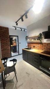 a large kitchen with a counter and a table and chairs at Apartament Przytulny 7- Harmonia, self check in, parking in Rzeszów