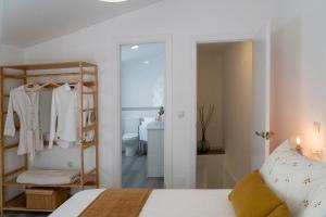 a white bedroom with a bed and a bathroom at Casa Isabela Olvera in Olvera