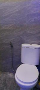 a bathroom with a toilet with a cord plugged into a wall at Kanaprime Hotels & Safaris Mtwapa Gem in Mtwapa +7 photos