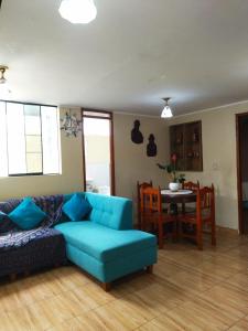 a living room with a blue couch and a table at Samay Wasi in Ayacucho