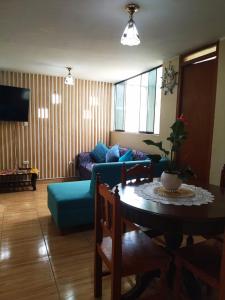 a living room with a blue couch and a table at Samay Wasi in Ayacucho