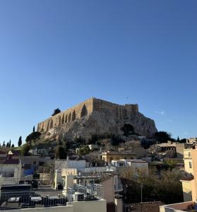 a view of the acropolis from the city of athens at Cozy Apartment with Acropolis View Rooftop Access in Athens