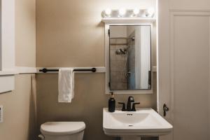 une salle de bain avec un lavabo, des toilettes et un miroir dans l'établissement December Group Retreat 4BR Victorian Home, UT & Downtown, à Austin 30 autres photos