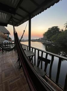 a hammock on a balcony with a view of the water at Karma Muse Hotel in La Libertad