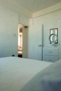 a white bedroom with a bed and a mirror at Victoria Green Living Place, Roseau in Roseau +14 photos