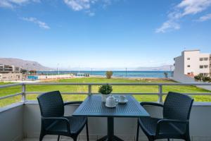 a table and chairs on a balcony with a view of the ocean at Sea Daffodil apartments in Kissamos