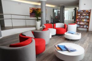biblioteca con mesas y sillas rojas y blancas en Apartamentos Vibra Tivoli, en Playa d'en Bossa