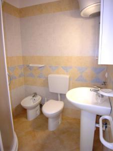 a bathroom with a toilet and a sink at Appartamenti Ai Pini in Bibione