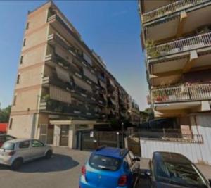 two cars parked in a parking lot in front of a building at Setta Apartment in Lido di Ostia