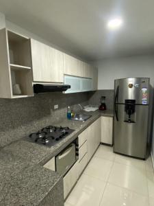 a kitchen with a stainless steel refrigerator and cabinets at Apartamento Amoblado de Lujo en Cucuta in Cúcuta