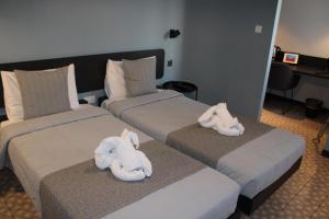two beds with stuffed animals on them in a hotel room at Victoria by Petit Chic in Mellieħa