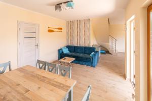 a living room with a blue couch and a table at Morski domek in Dębki