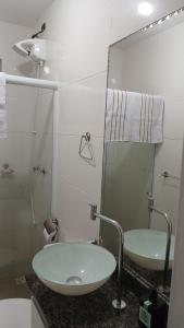 un bagno bianco con lavandino e specchio di Apart 2 qdras da Praia do Recreio a Rio de Janeiro Altre 15 foto