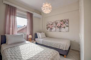 a bedroom with two beds and a chandelier at Sea Daffodil apartments in Kissamos