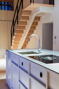 a kitchen with a sink and a staircase at Zuhaus Freiweidach - Design Holiday Home Chiemgau in Aschau im Chiemgau