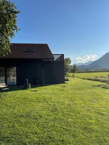 a building in a field with a grass yard at Zuhaus Freiweidach - Design Holiday Home Chiemgau in Aschau im Chiemgau