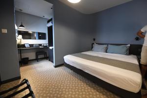 a bedroom with a bed and a desk in it at Victoria by Petit Chic in Mellieħa