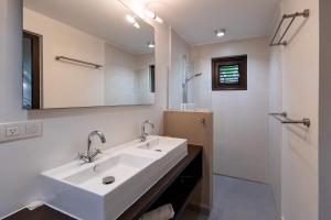 a white bathroom with a sink and a shower at Blue Bay's Tropical Escape in Willemstad +22 photos