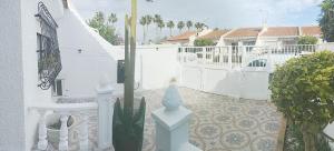 a white fence next to a white house with a cactus at El Rincón de Sotillo beach in Los Alcázares