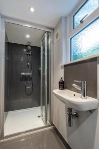 a bathroom with a sink and a shower at Chic 1-bed Garden Flat, London, Convenient for Tower Bridge, Great Public Transport in London +16 photos