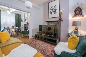 a living room with a couch and a television at Chic 1-bed Garden Flat, London, Convenient for Tower Bridge, Great Public Transport in London