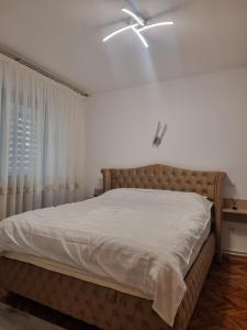 a bedroom with a bed with a ceiling fan at 8 MAI Residence in Târgu Jiu