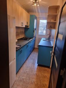 a kitchen with blue cabinets and a blue counter top at 8 MAI Residence in Târgu Jiu