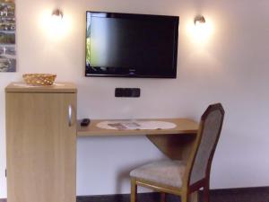Zimmer mit einem Schreibtisch und einem TV an der Wand in der Unterkunft Apartment in Oberkirchen near Winterberg Skiing in Schmallenberg + 32 Fotos