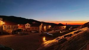 a town with cars parked in a parking lot at sunset at Casa Amarela - Aldeias - Serra da Estrela in Gouveia