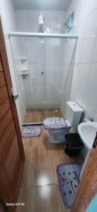 a bathroom with a shower and a toilet and a sink at Pousada Malibu itaoca praia in Itapemirim