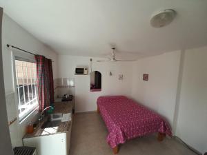 a bedroom with a bed with a purple bedspread at Departamentos Tere in Las Grutas +24 photos