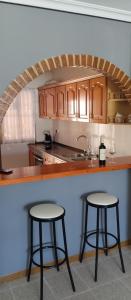 a kitchen with two bar stools and a counter top at El Rincón de Sotillo beach in Los Alcázares