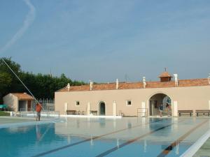 an empty swimming pool with a building in the background at Camping du Pontis in Verteillac