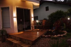 a wooden deck with a pond in front of a house at Suíte Santa Catarina in Pomerode