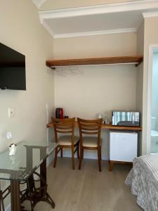 a living room with a table and chairs and a bed at Suíte Santa Catarina in Pomerode