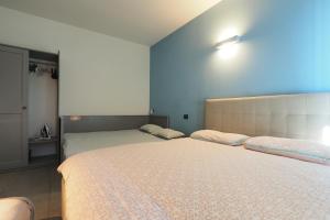 two beds in a bedroom with blue walls at CITY CENTER - Modern flat with FREE PARKING and WIFI - Apt A in Bergamo +30 photos