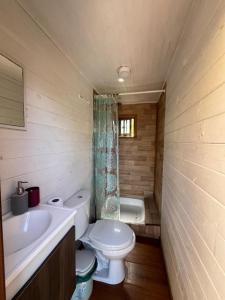 Un baño pequeño con inodoro y lavabo. en Tiny house Hostal, en Pichilemu