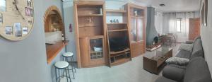 a living room with a couch and a tv at El Rincón de Sotillo beach in Los Alcázares