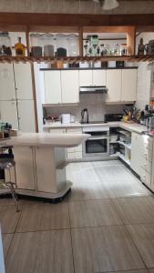 a kitchen with white cabinets and a white counter top at Habitaciones Dobles Valdivia, Isla Teja in Valdivia +7 photos