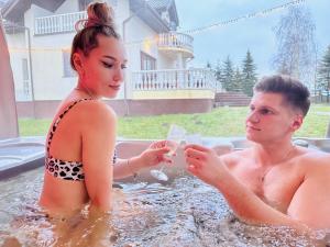 a man and a woman in a bath tub at Guesthouse Sauna Jacuzzi Free parking in Dobrzewino