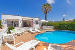 a villa with a swimming pool and lounge chairs at Villa Joel - Casa con piscina cerca de la playa in Son Carrio
