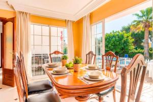 a dining room with a table and chairs and a large window at Villa Joel - Casa con piscina cerca de la playa in Son Carrio