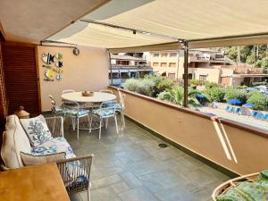 Un patio con una mesa y sillas en un balcón. en Residence Costa degli Ulivi, en Porto Santo Stefano 7 fotos más