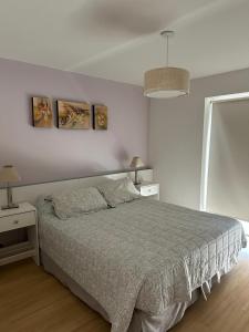 a bedroom with a bed and two pictures on the wall at Boulogne Design Suites in Mendoza