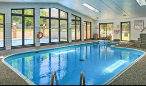 a large swimming pool with blue water in a building at Spacious Retreat, Heart of the City, Indoor Pool, Free Attraction Tickets! in Branson